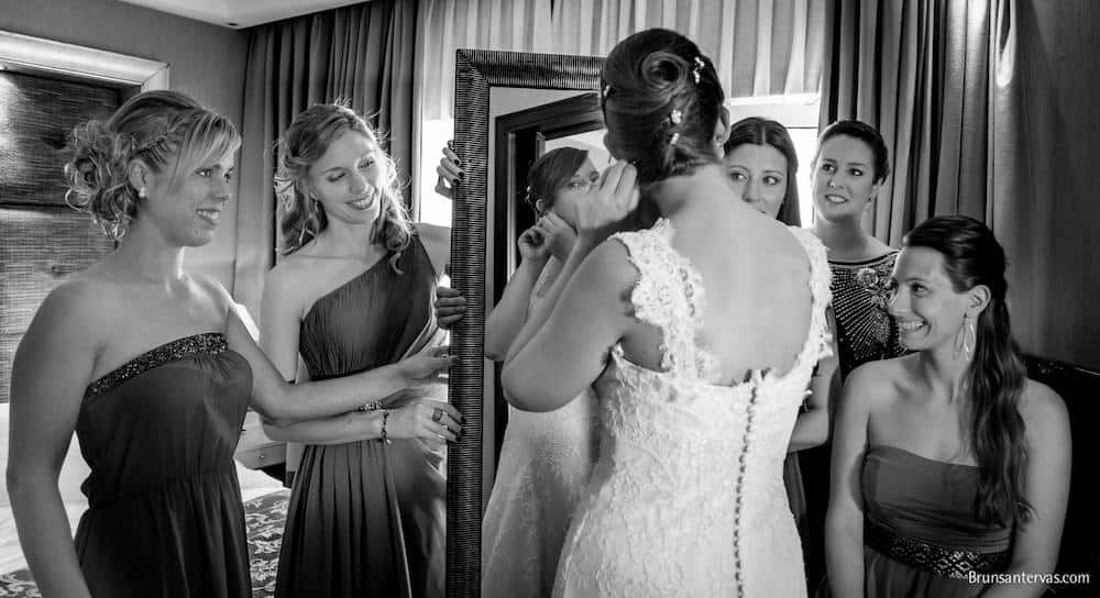 Damas de honor ayudando a vestirse a la novia.