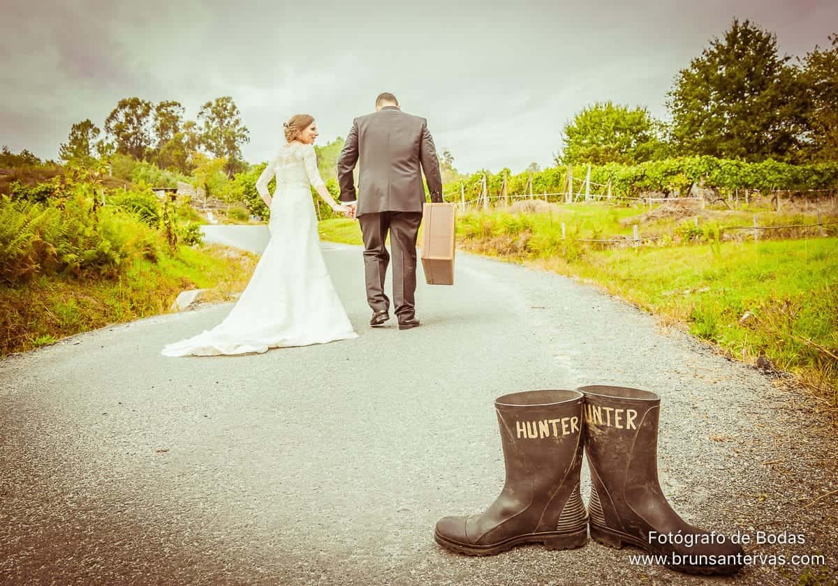 Foto posado novios caminando por el campo.
