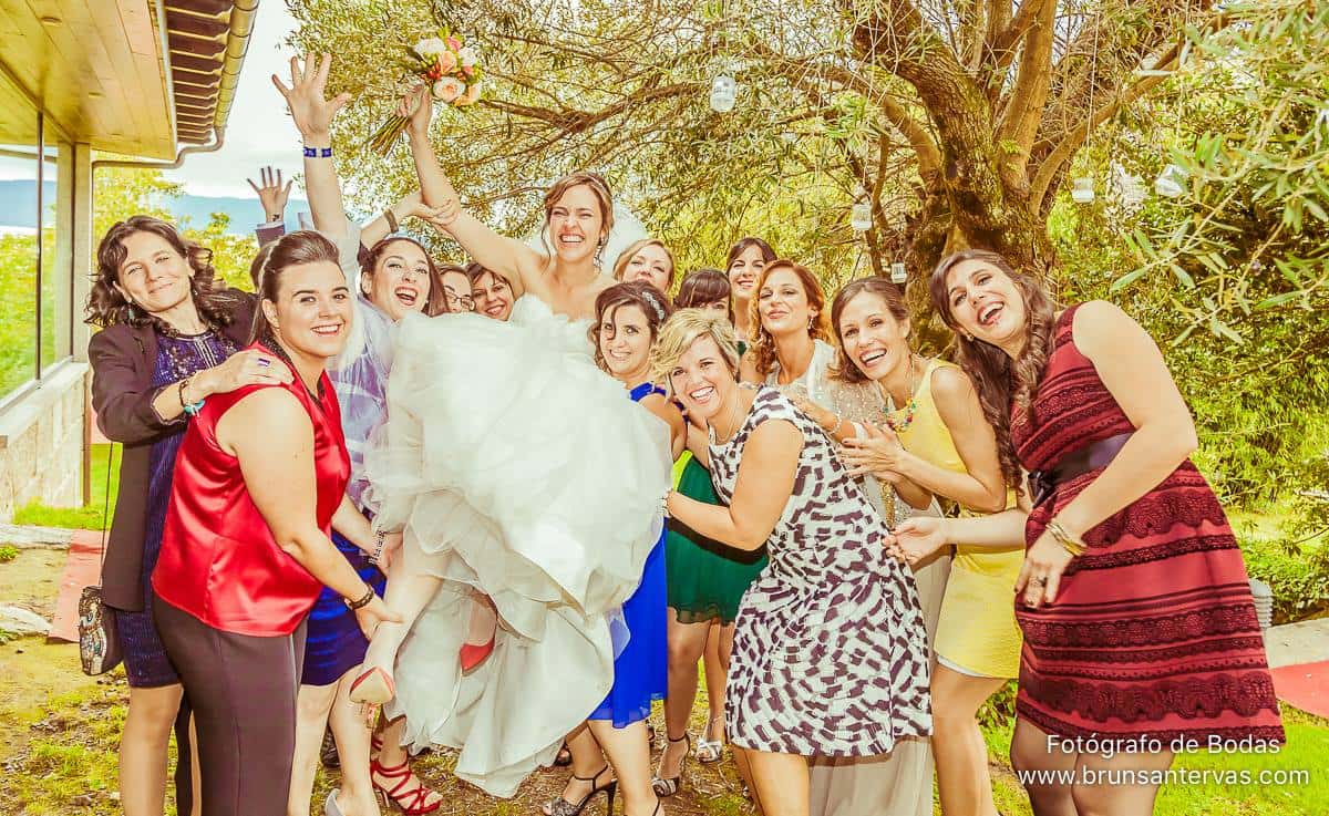 Invitadas cogiendo novia en brazos.