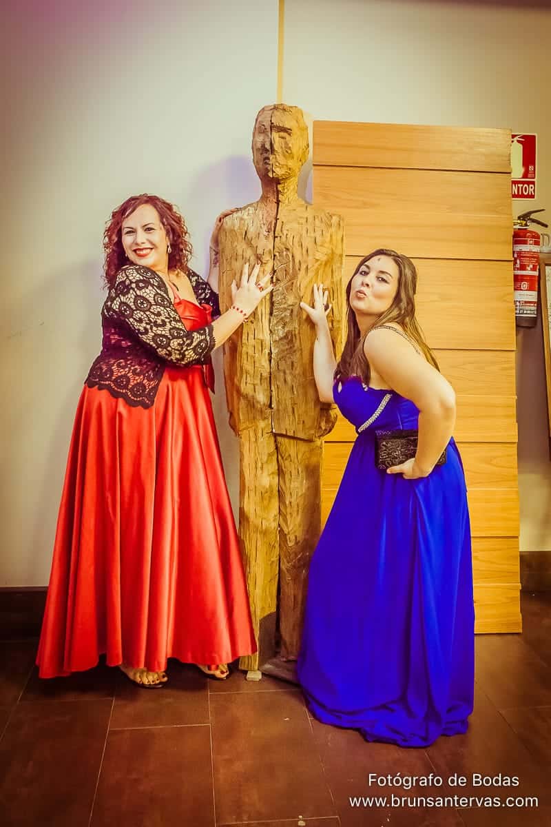 Invitadas de boda posando con una estatua