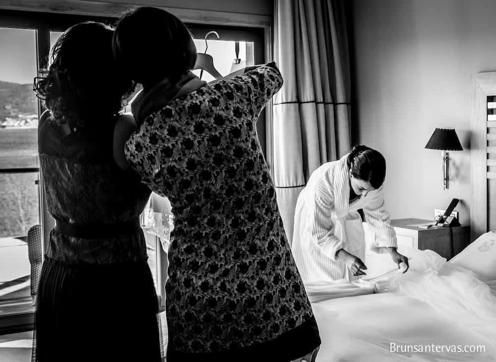 Novia con albornoz preparando su vestido de novia.