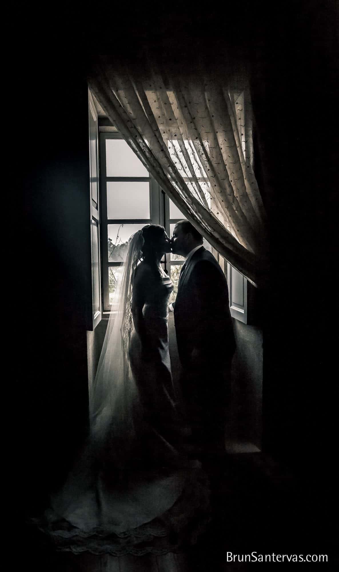 Novios besándose a contra luz.
