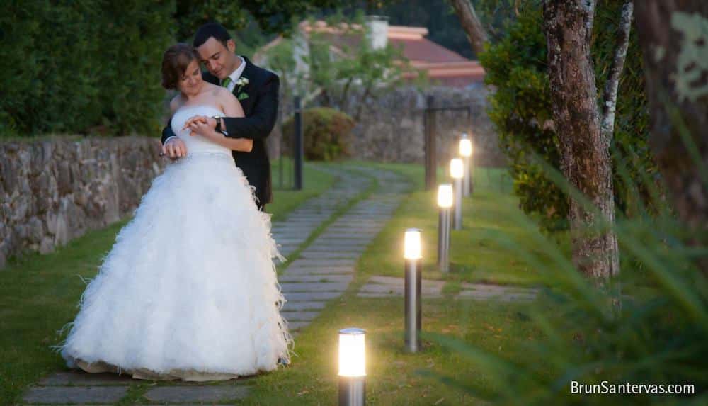 Novios paseando por jardín.