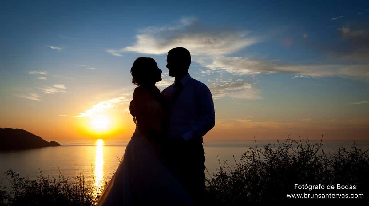 Novios posando en puesta de sol.